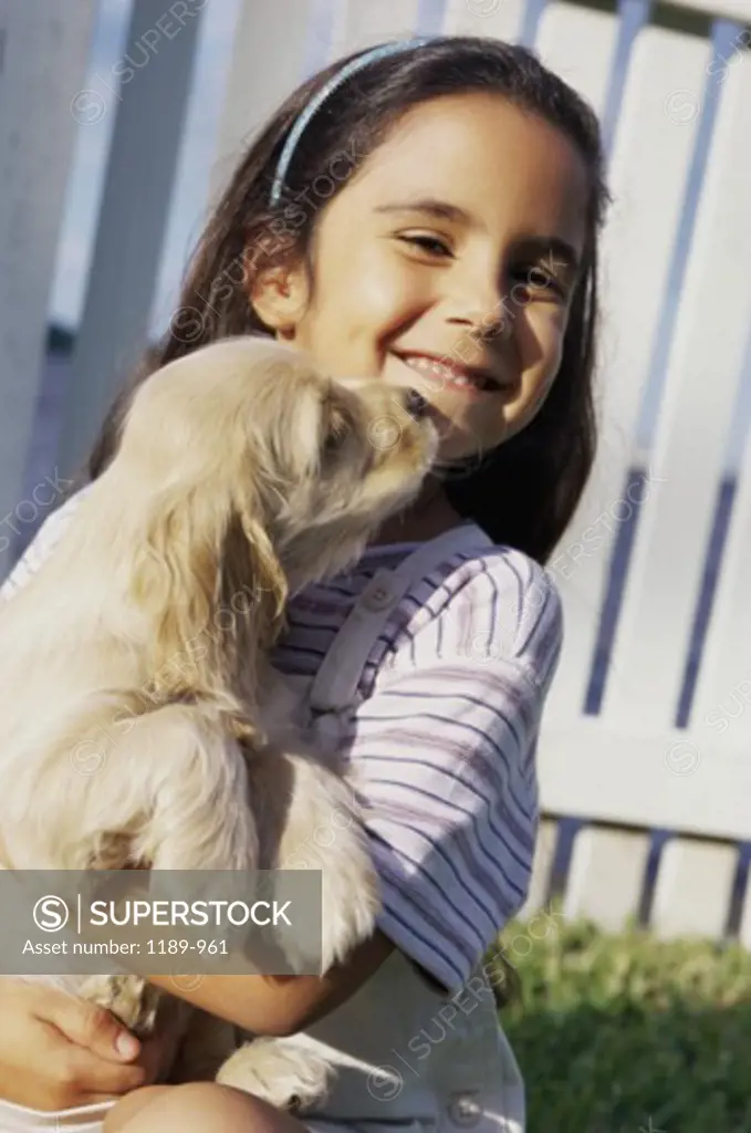 Portrait of a girl holding a puppy