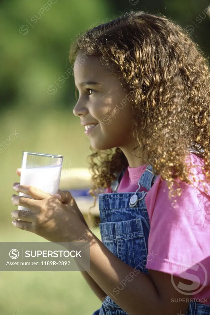 Side profile of a girl holding a glass of milk