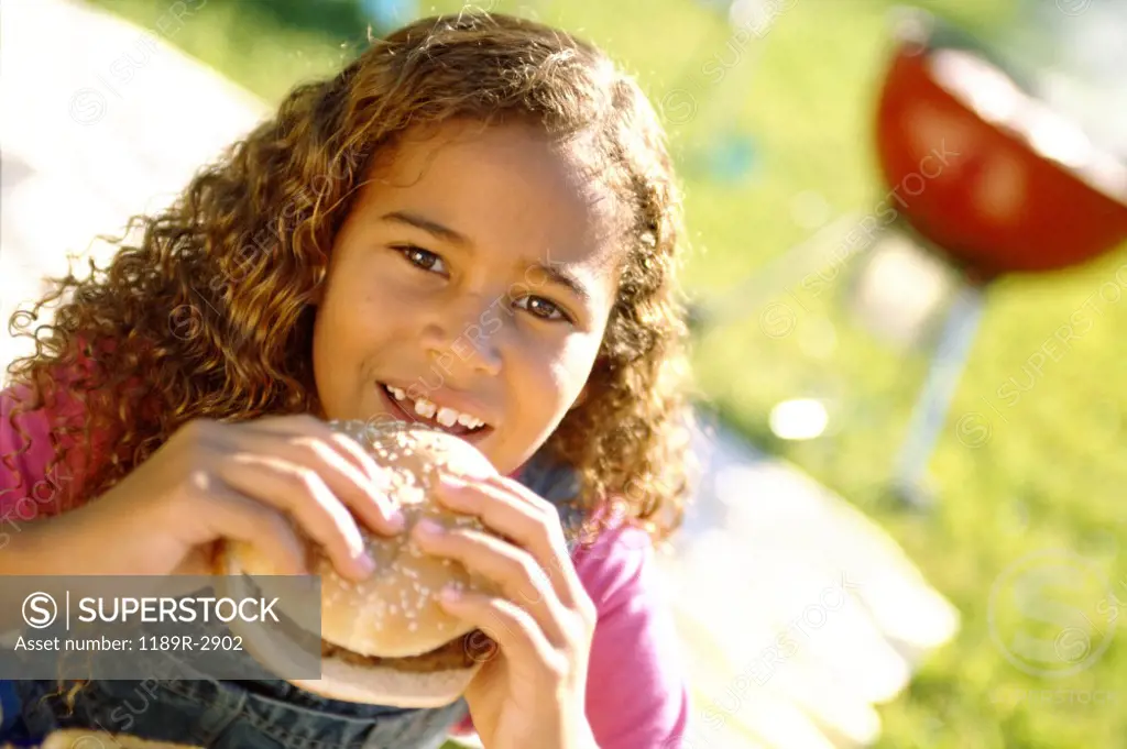 Portrait of a girl eating a hamburger