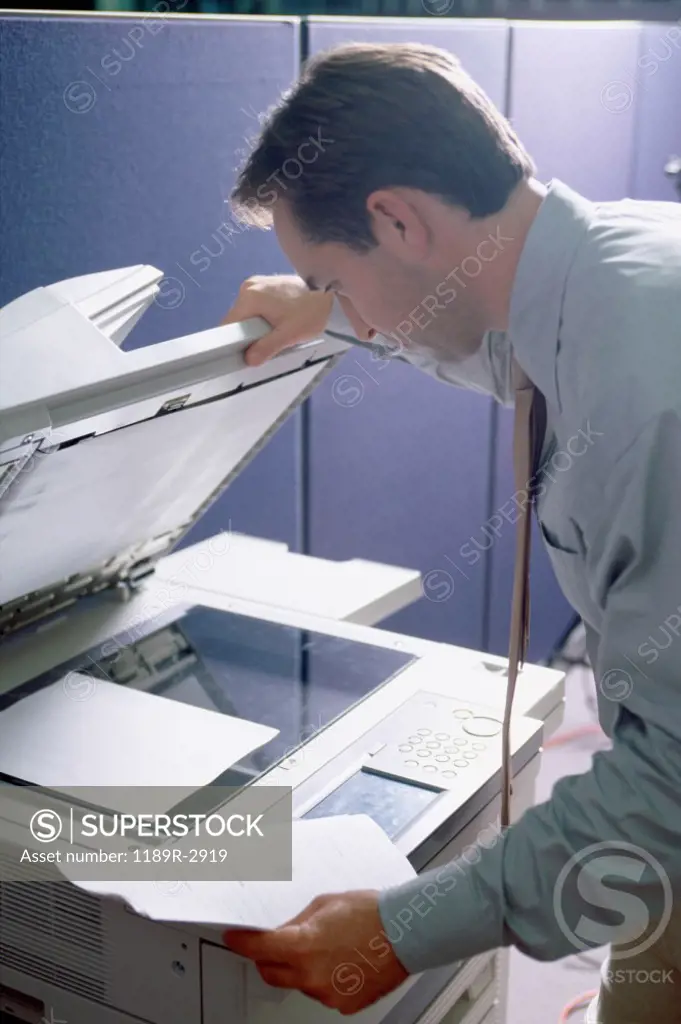 Side profile of a businessman using a photocopier machine
