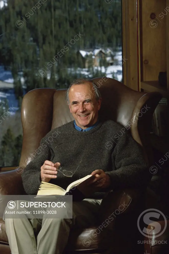 Portrait of a senior man holding a book