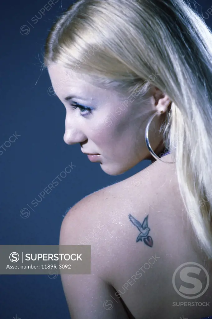 Rear view of a young woman with a tattoo on her shoulder