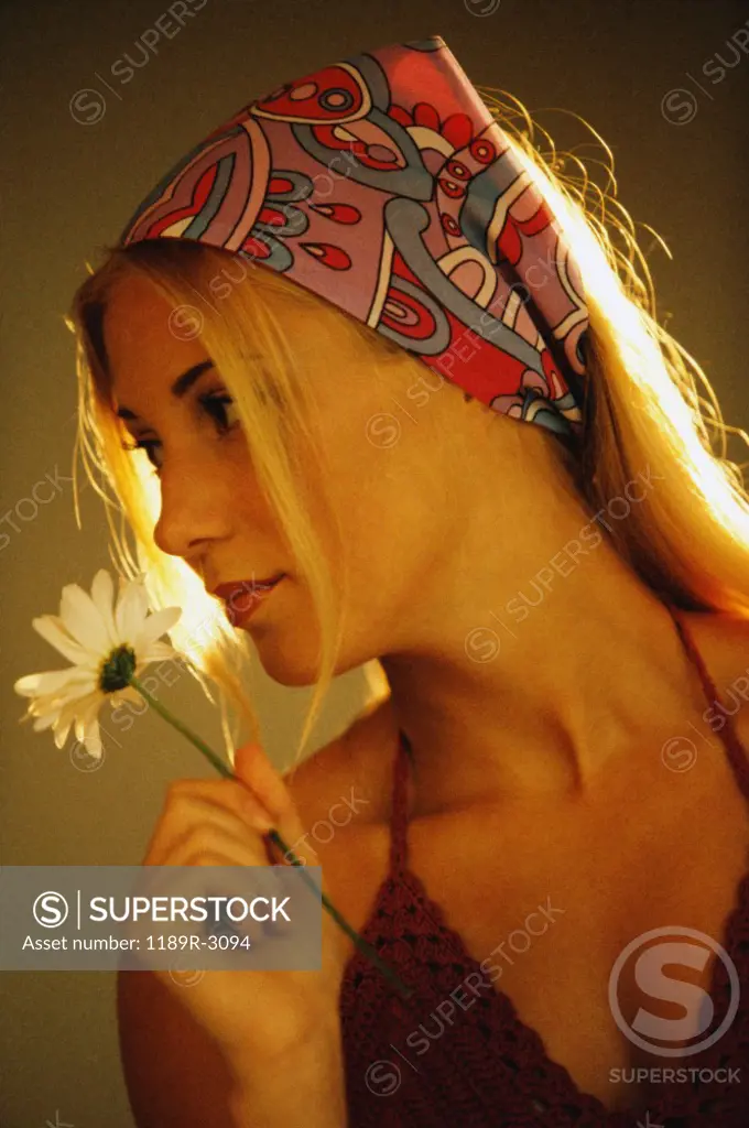 Young woman in profile holding a flower