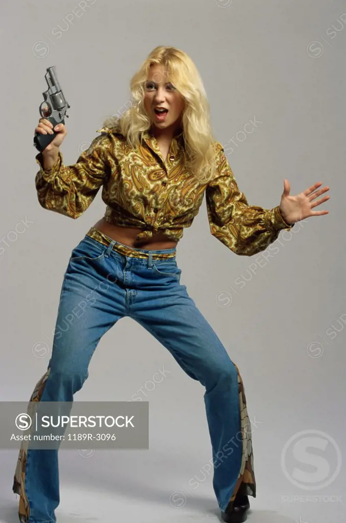 Portrait of a young woman holding a handgun