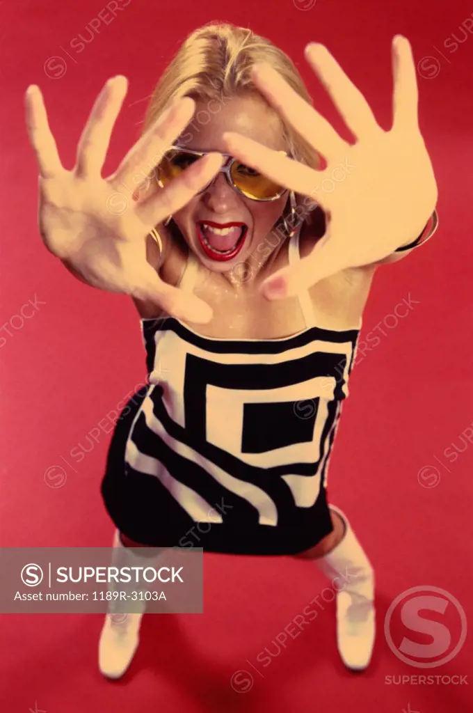 Portrait of a young woman with her hands in front of her face