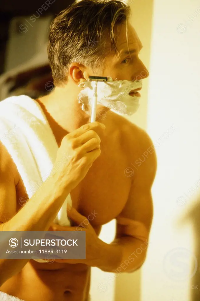 Side profile of a mid adult man shaving