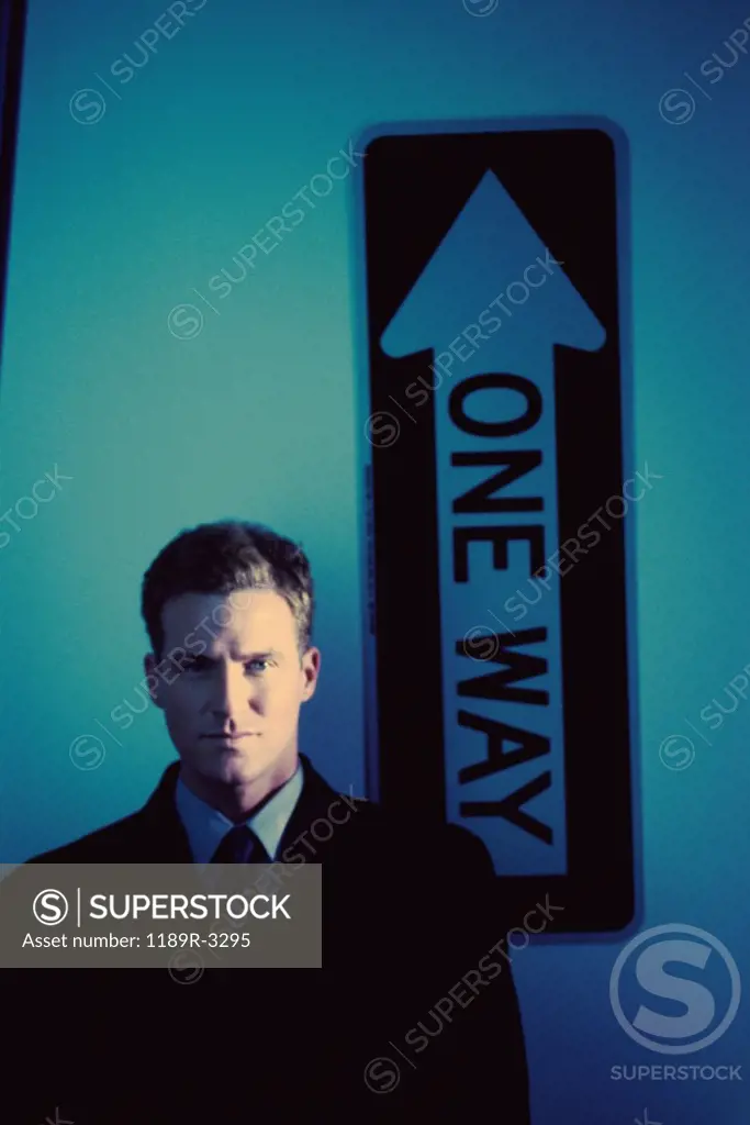 Portrait of a businessman standing in front of a street sign