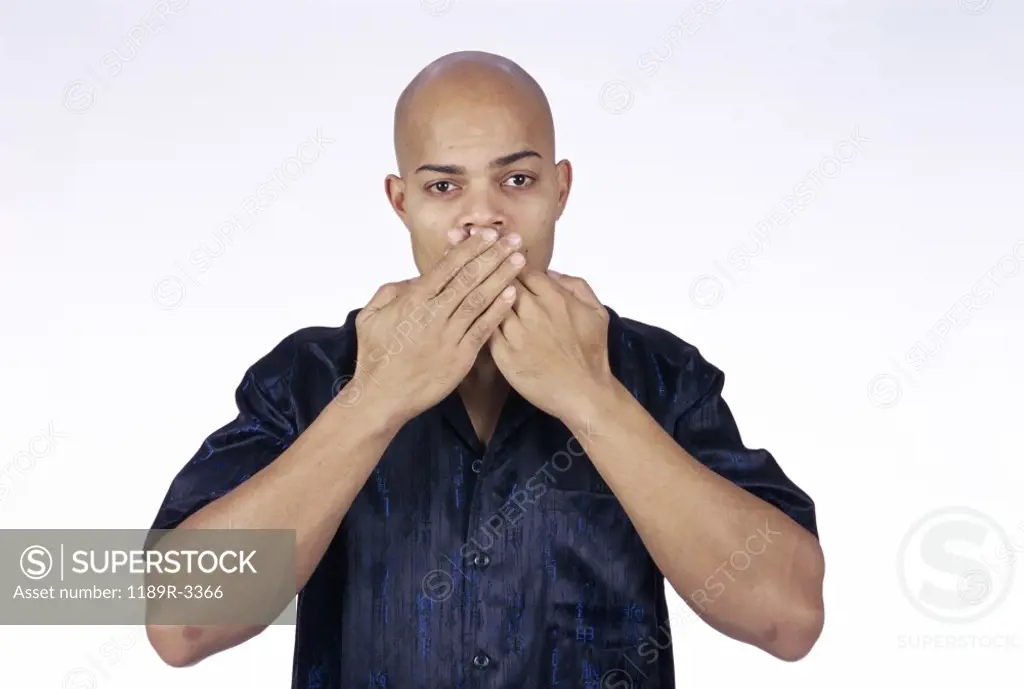 Young man with his hands on his mouth