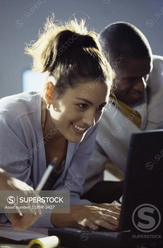 Businessman and a businesswoman working in front of a laptop