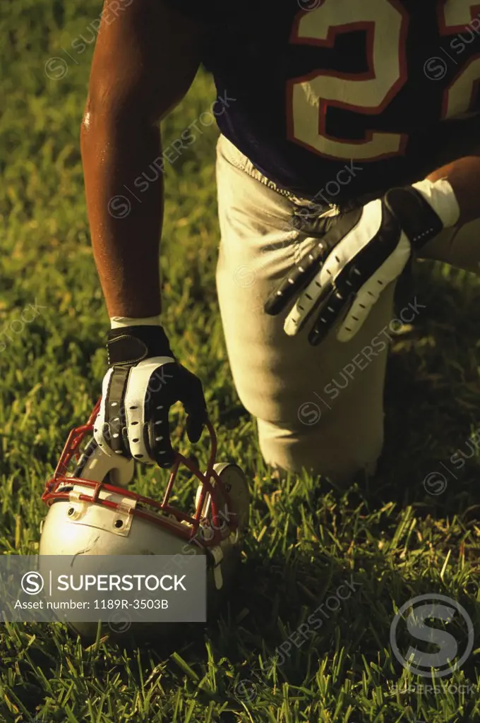 American football player kneeling on the field