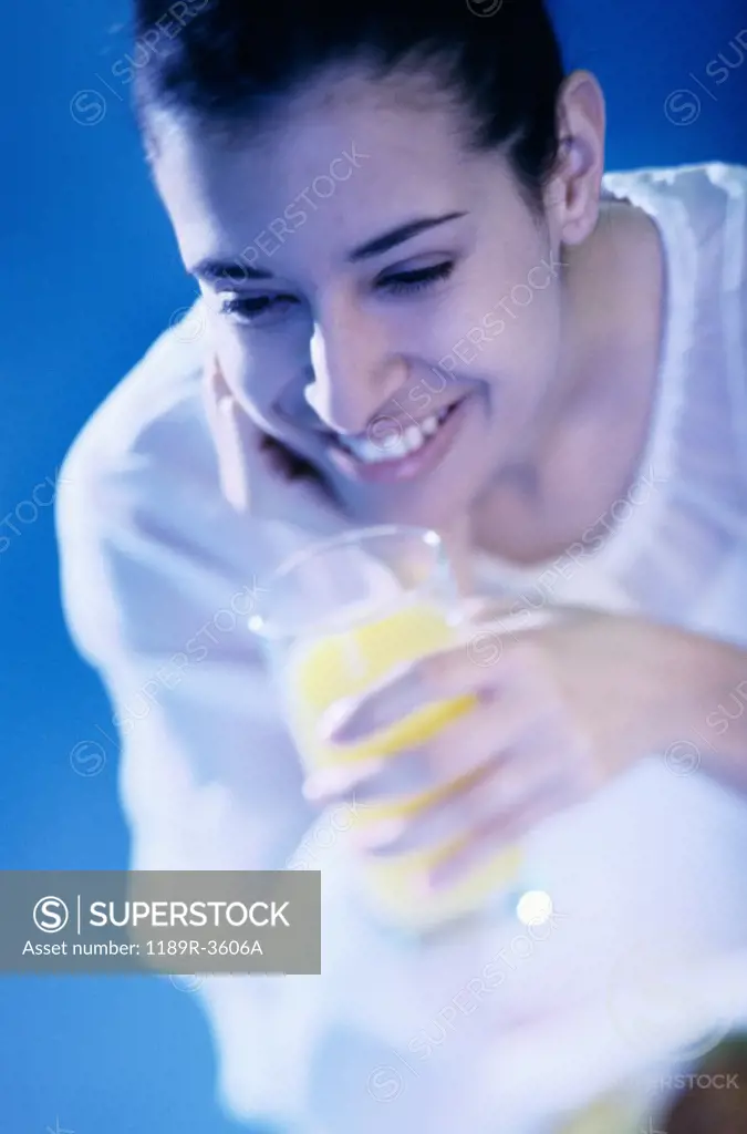 High angle view of a young woman holding a glass of orange juice
