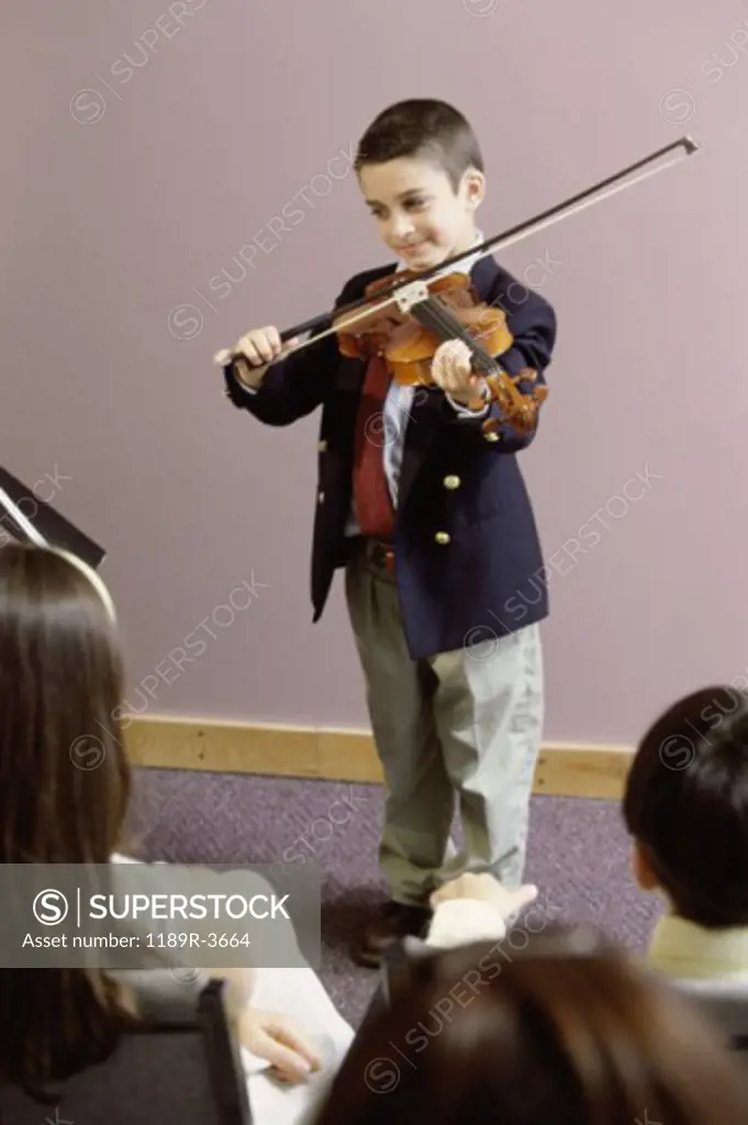 Boy playing a violin in front of an audience