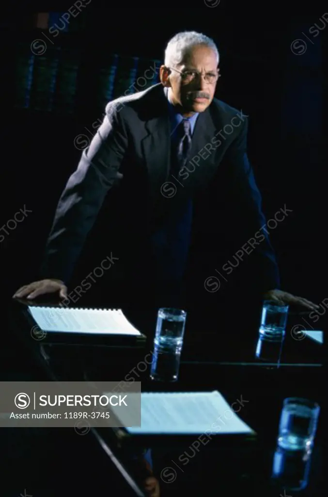 Businessman leaning against a table