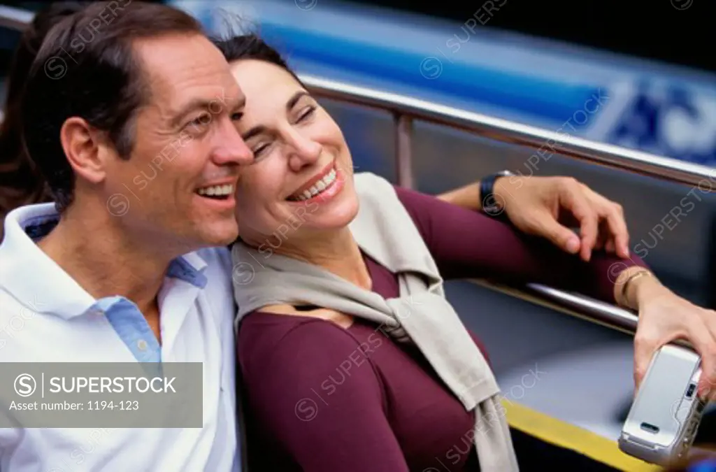 Mid adult couple sitting together in a double decker bus