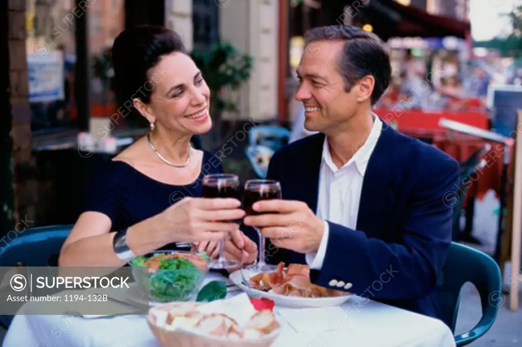 Mid adult couple sitting together toasting at a restaurant