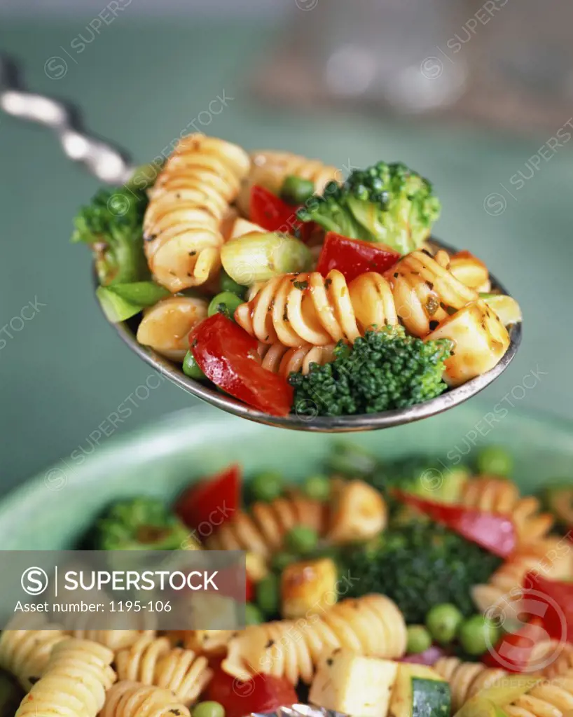 Close-up of a spoon of rigatoni over a bowl