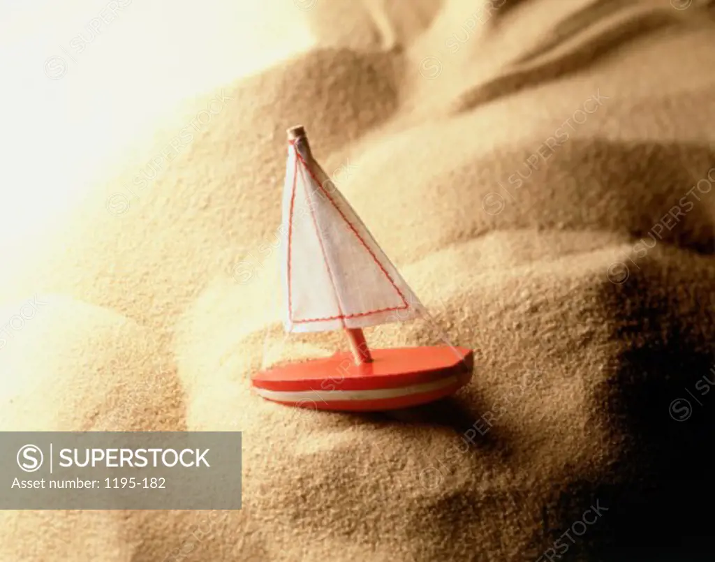 Close-up of a toy sailboat on the sand