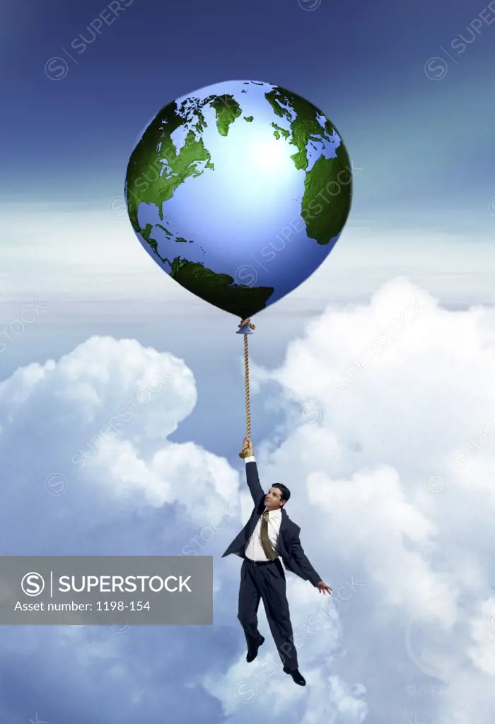 Businessman holding onto a floating globe