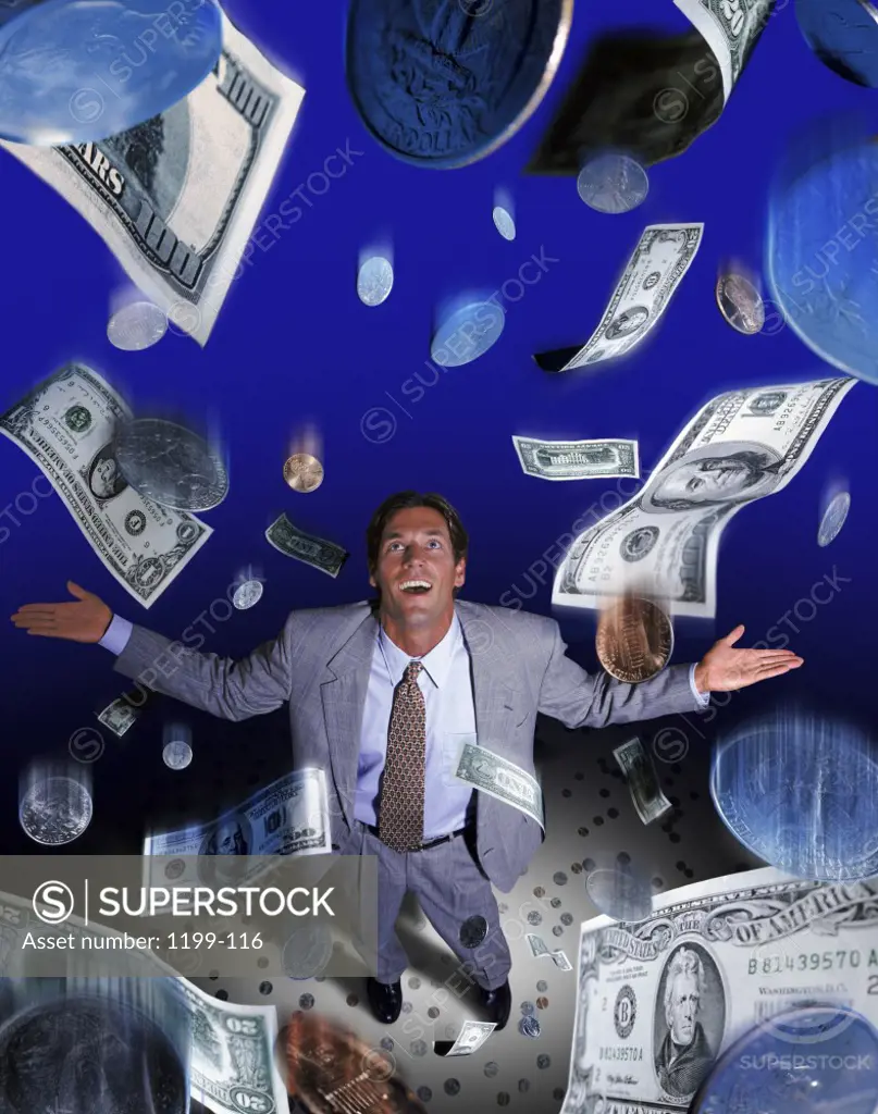 American dollar bills and coins raining down on a businessman