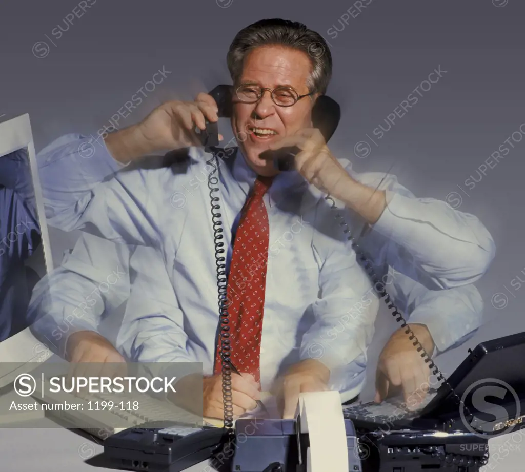 Businessman talking on two telephone receivers