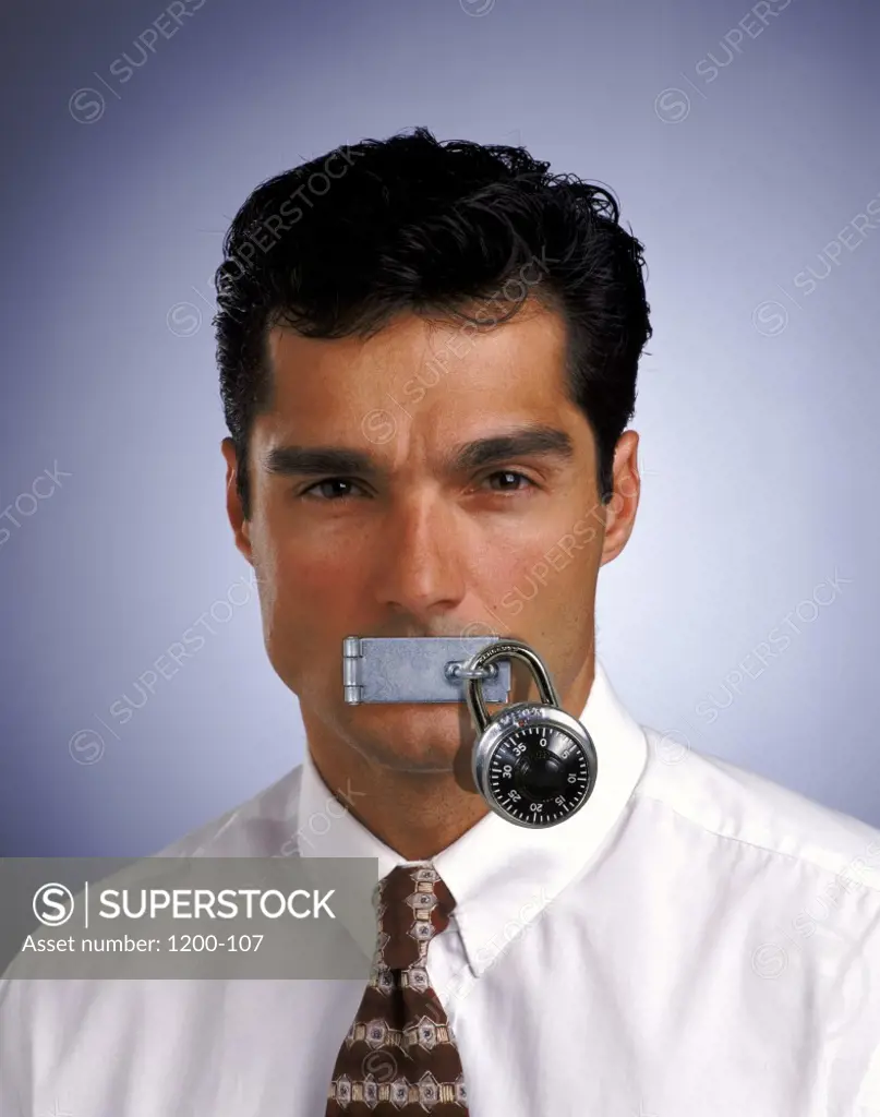 Portrait of a businessman with his lips padlocked