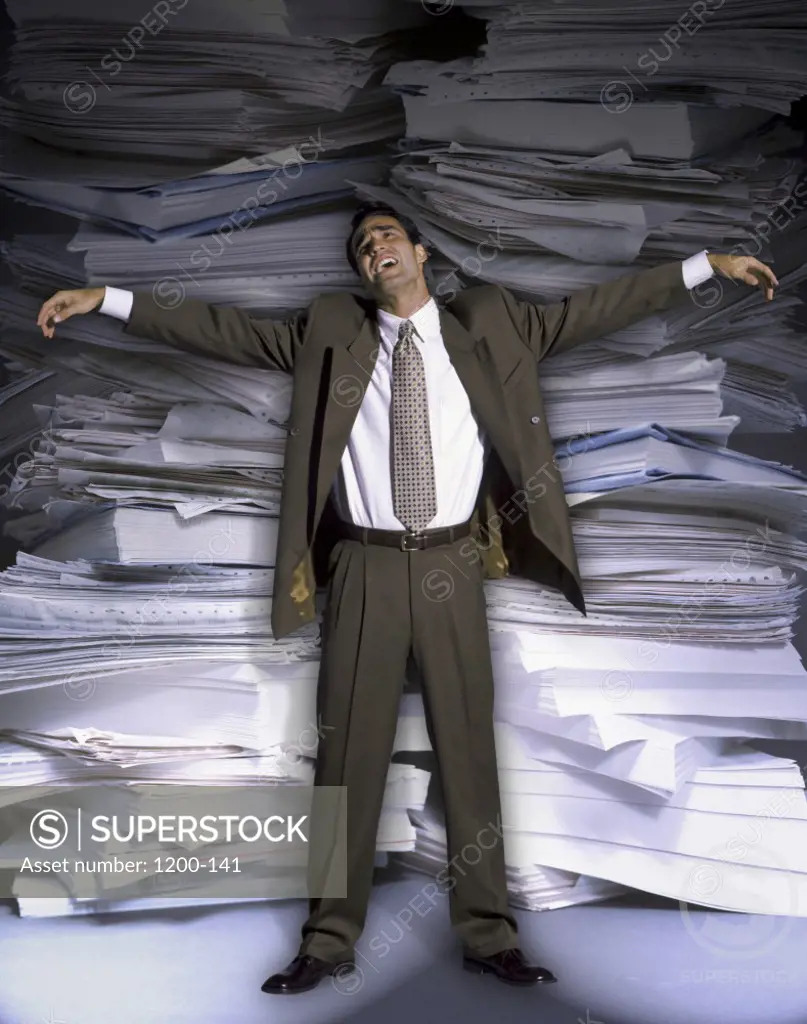 Businessman standing against a stack of papers