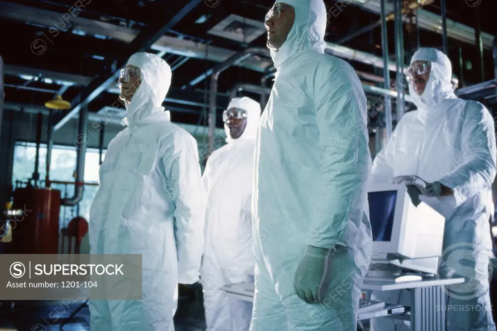 Group of scientists wearing protective clothing standing in a laboratory