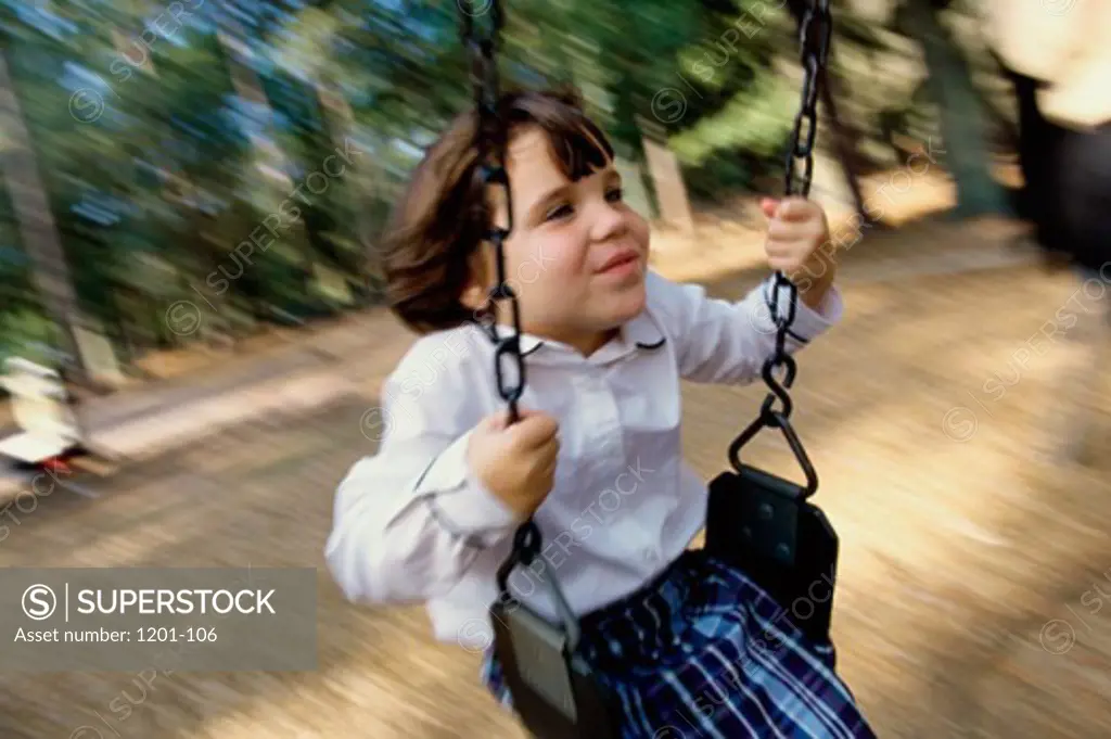 Close-up of a girl swinging on a swing