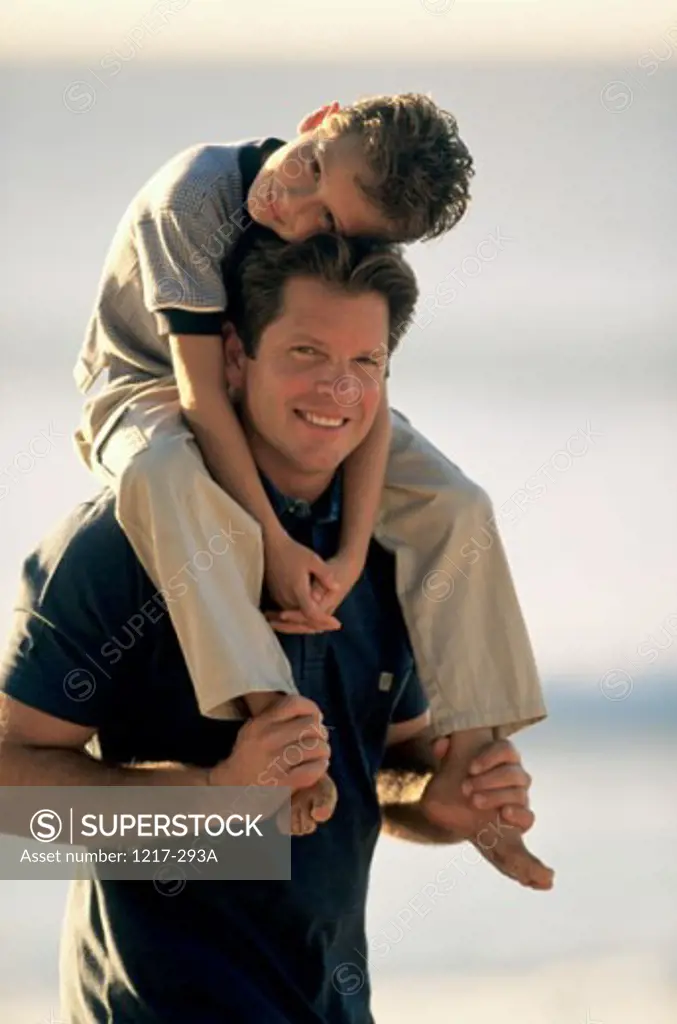 Portrait of a mid adult man carrying his son on his shoulders