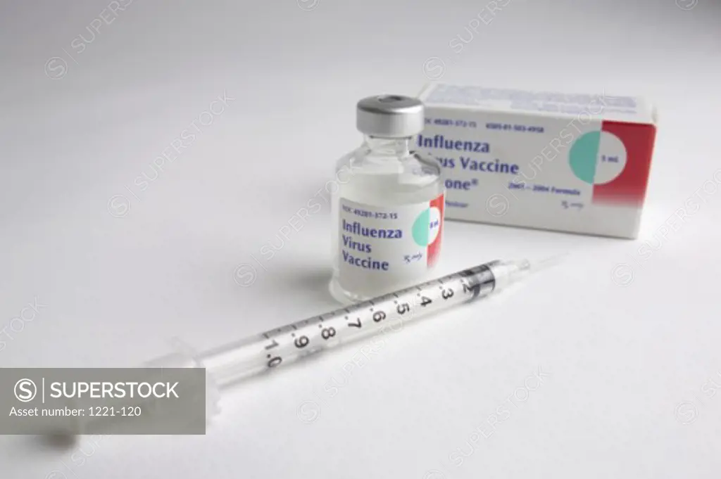 Close-up of a syringe with a flu vaccine bottle
