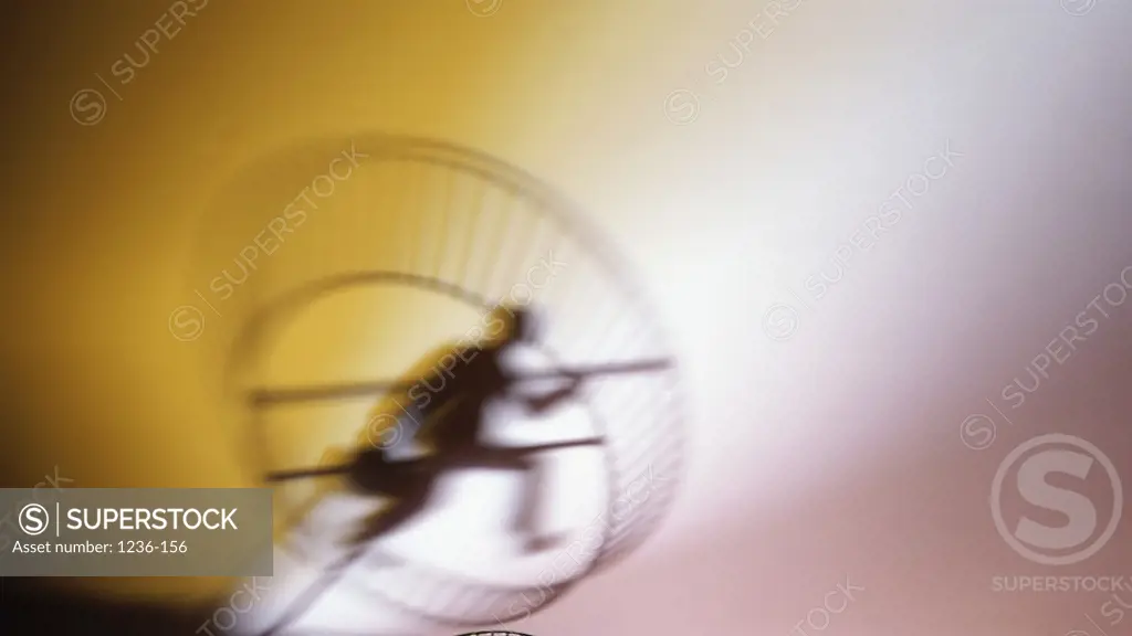 Silhouette of a businessman running in an exercise wheel