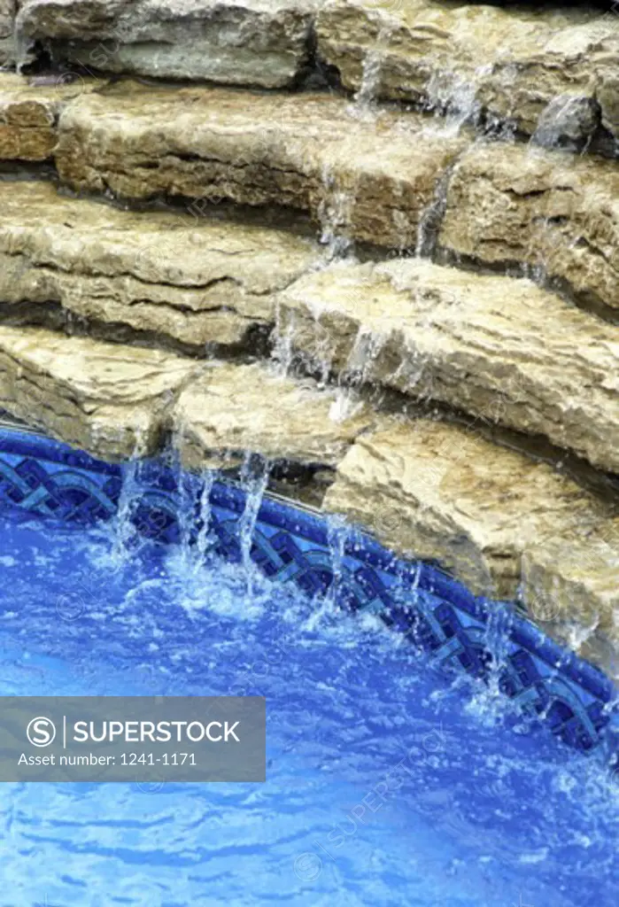 Water flowing through rocks into a swimming pool