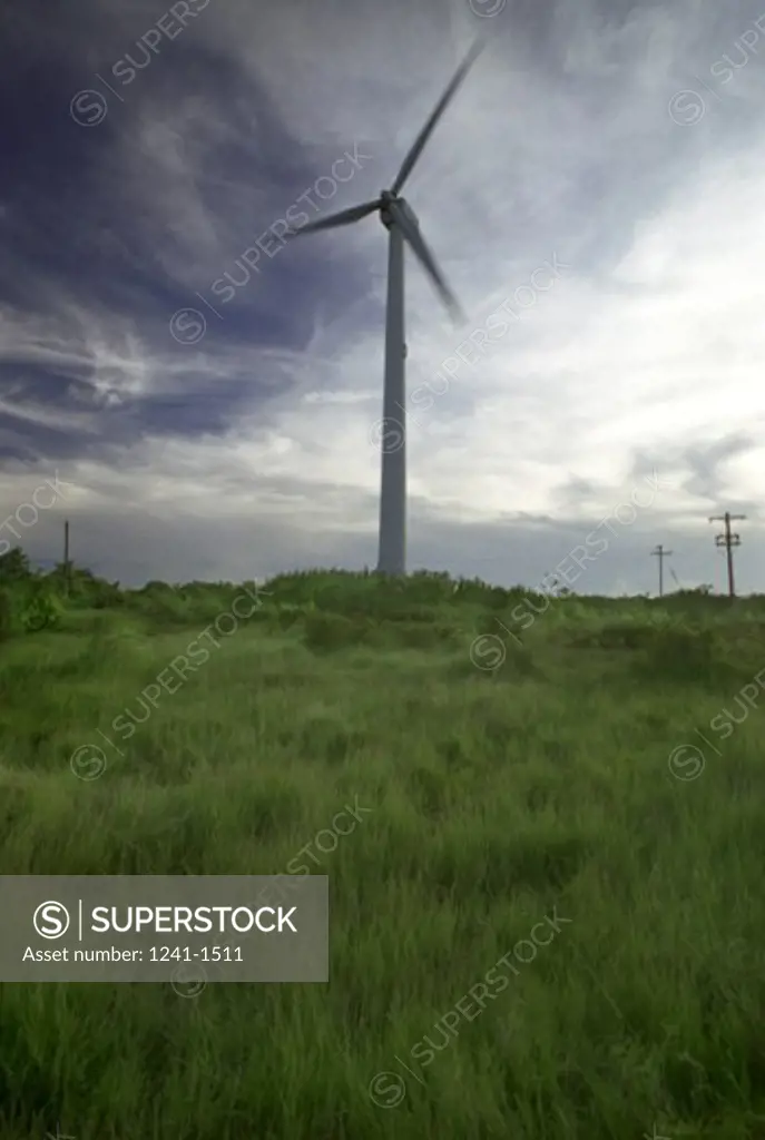 Low angle view of windmill on a grassy hill