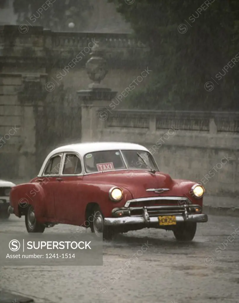 Car on the road in rain, Santiago de Cuba, Cuba