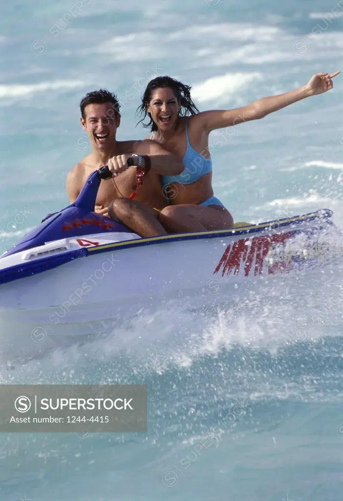 Portrait of a mid adult couple riding a jet ski
