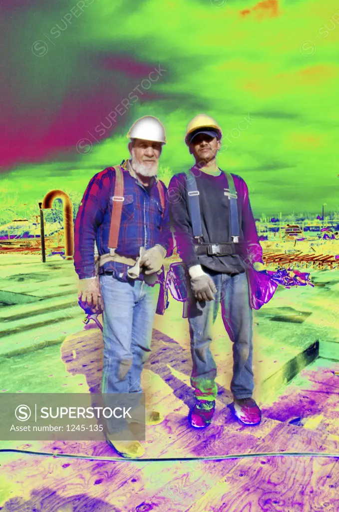 Two workers at a construction site wearing hardhats
