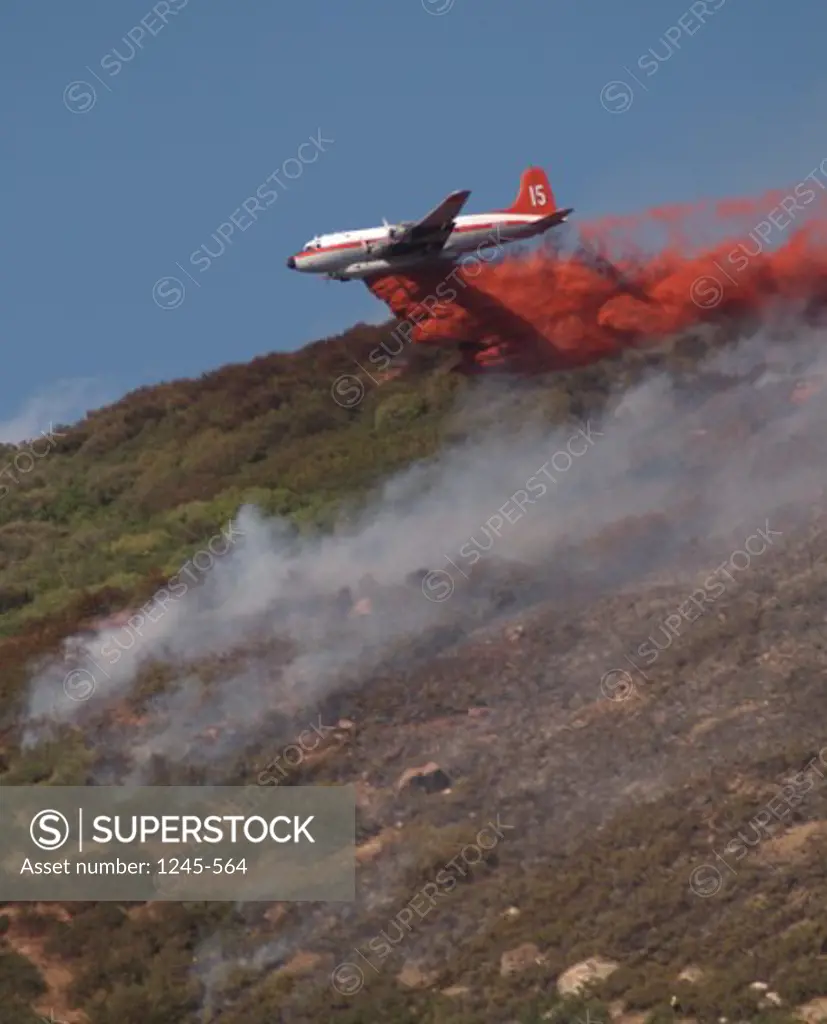 Fire fighting plane dumping water over a forest fire, Farmington, Utah, USA