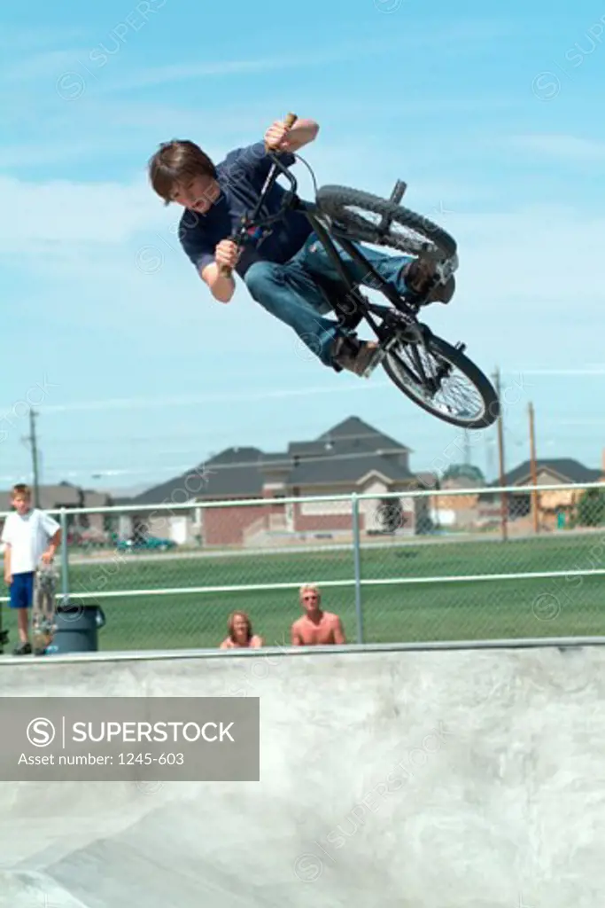 Low angle view of a teenage boy performing a stunt on a bicycle