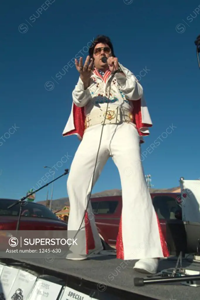 Low angle view of an Elvis impersonator performing on a stage