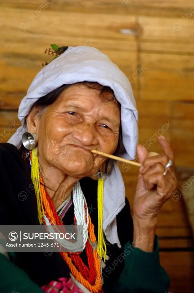 Thailand, Chang Mai, Elderly indigenous woman from Lahu Shi Baiah tribe smoking pipe