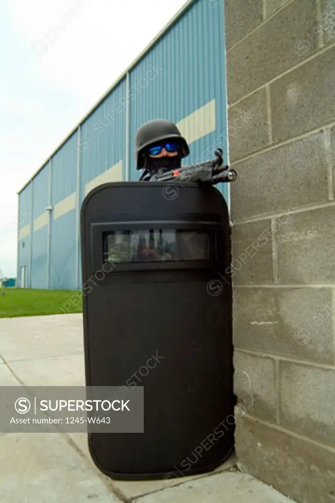 SWAT team member taking position behind a riot shield