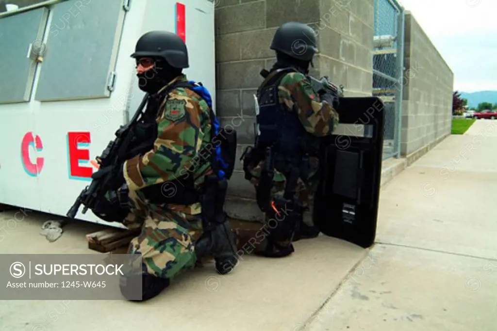 Side profile of two SWAT team members taking position