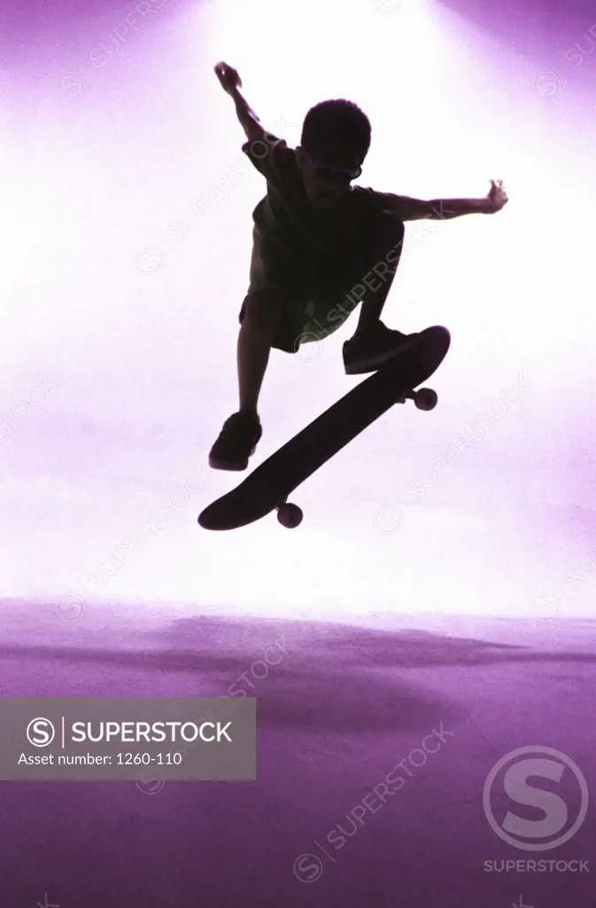 Silhouette of a boy skateboarding