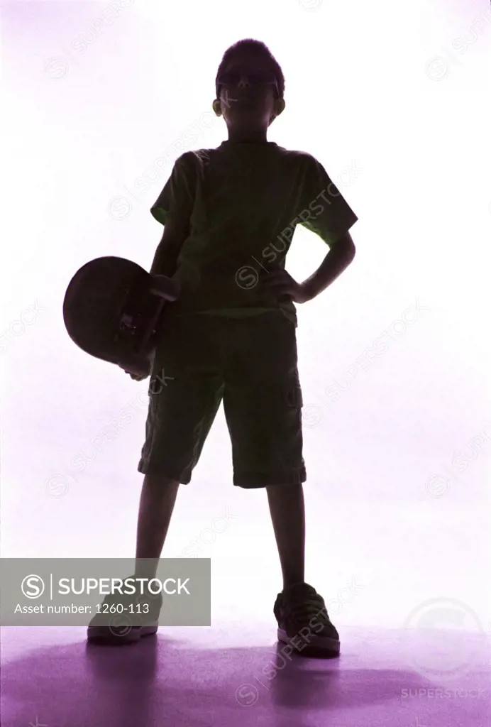 Silhouette of a boy holding a skateboard