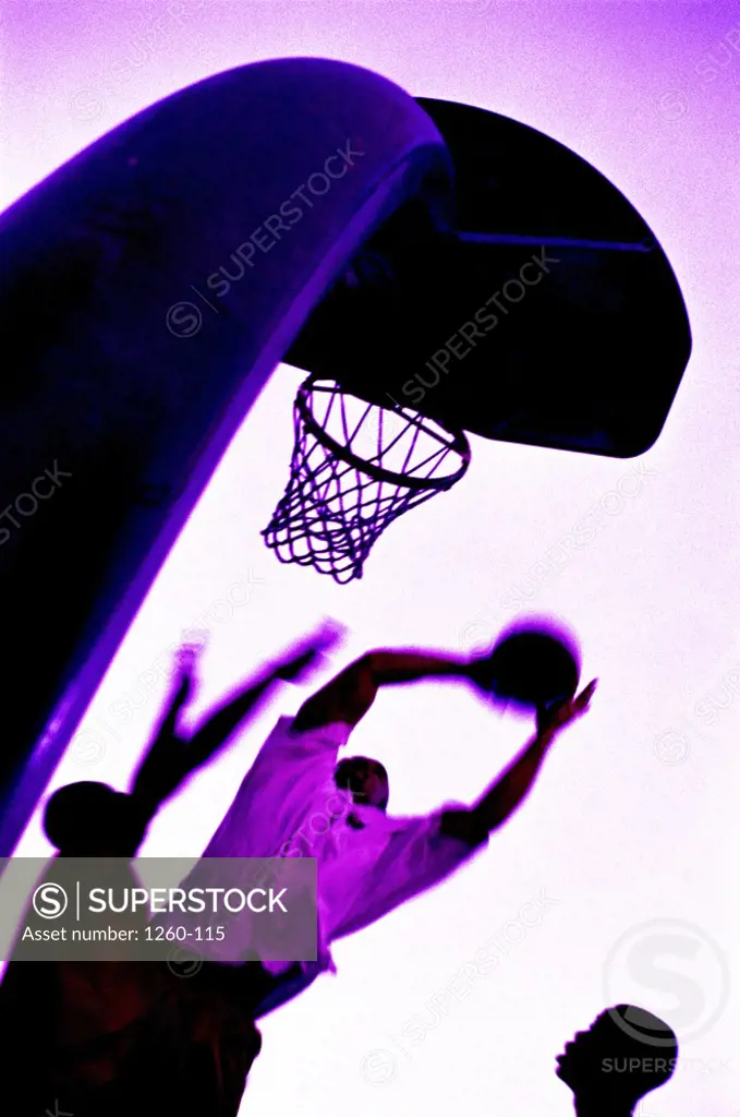 Silhouette of three men playing basketball