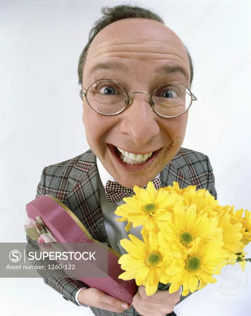 Close-up of a man holding a box of chocolates and a bouquet of flowers