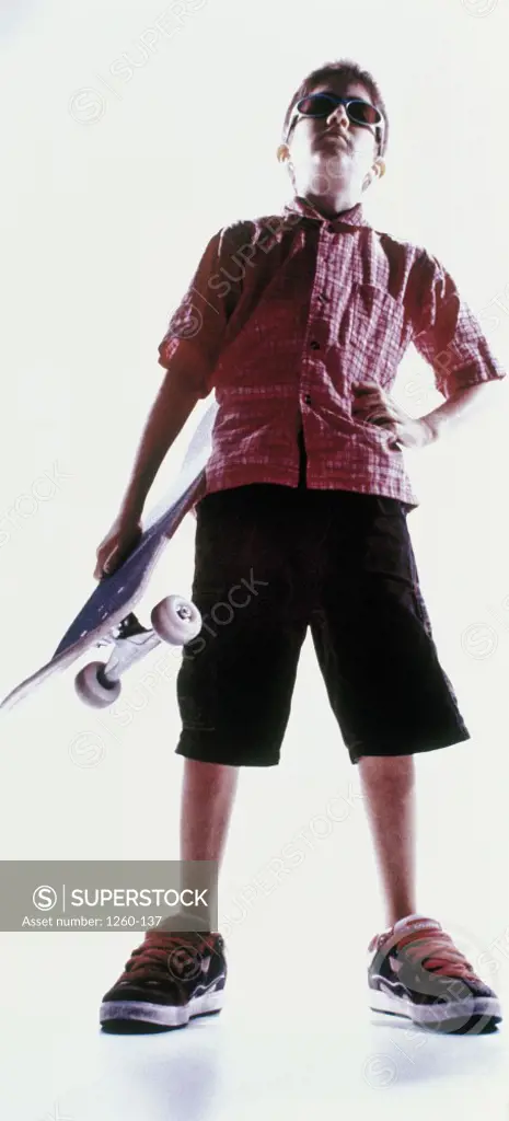 Low angle view of a boy holding a skateboard