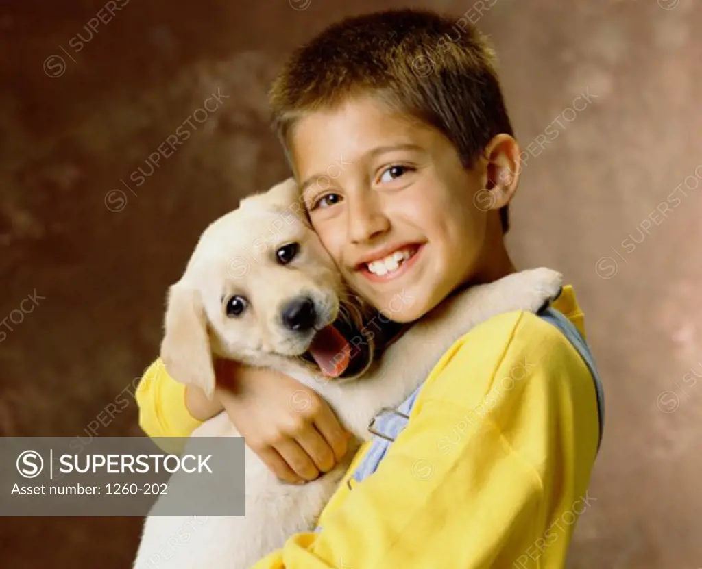 Portrait of a boy hugging his puppy