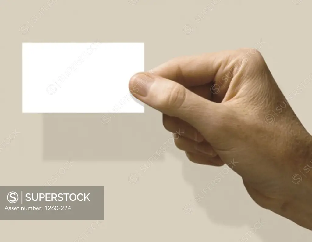 Close-up of a human hand holding a business card