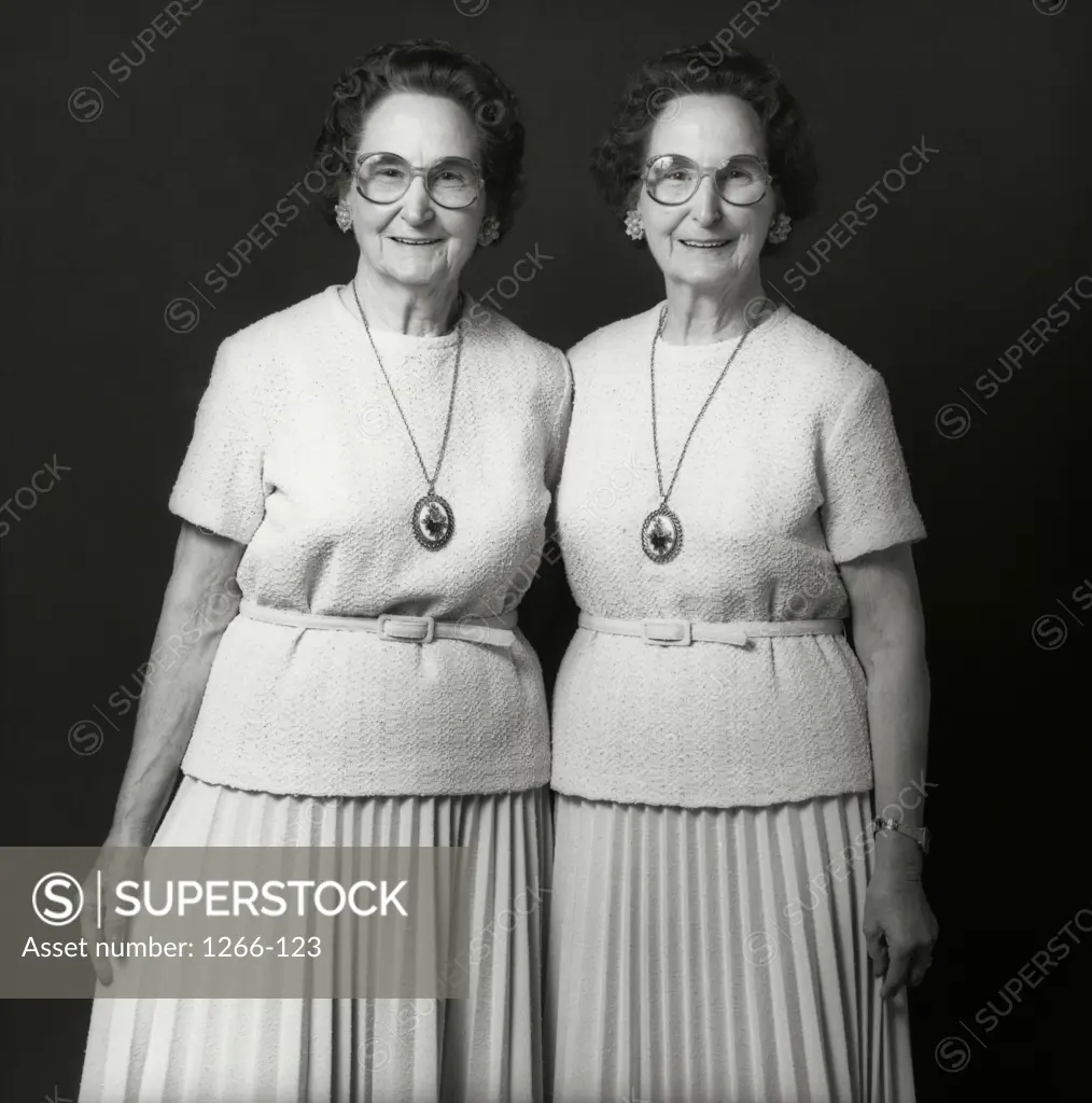 Portrait of twins standing together smiling
